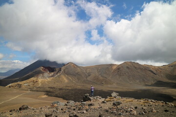 Hikers making their way up a volcanic ridge in New Zealand, surrounded by steaming crater rocks and breathtaking views. A challenging and rewarding trek.