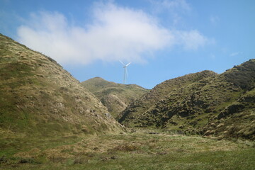 Hiking trail through New Zealand’s rolling hills with scenic mountain views. A perfect representation of adventure, exploration, and outdoor travel.