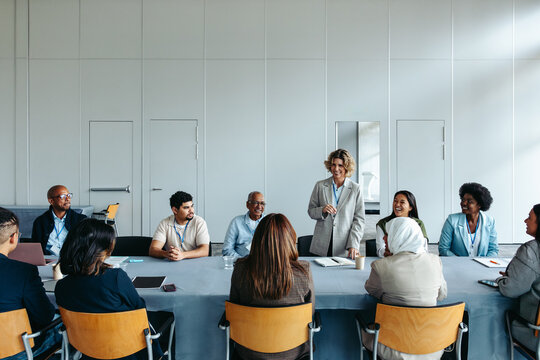 Mature female leader addressing team during business meeting - Powered by Adobe