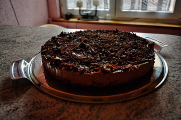 Chocolate cake on a plate in a kitchen