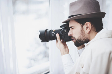 Private detective agency. Man is taking photos in window.