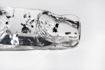 Glass pipette with cosmetic liquid with silver particles.