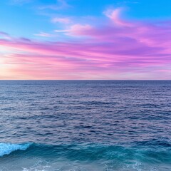 Obraz premium Soft pastel sunset sky with pink hues over calm ocean waters reflecting gentle colors