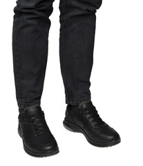 Man's legs in dark denim jeans wearing black leather casual lace-up shoes. Isolated on transparent...