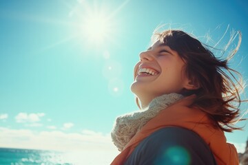 A woman smiling while gazing up at the clear blue sky