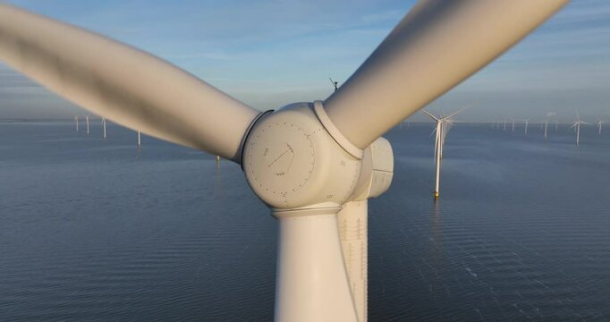 Aerial close up views of large windturbines on water, offshore wind park.