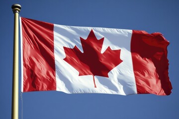 A Canadian flag waving freely in a bright blue sky