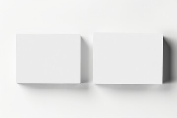 Two high-definition white business cards are set on a smooth white surface, ideal for customization or design purposes in a professional setting