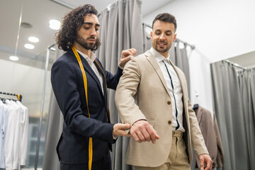 Tailor adjusting suit fit for client in a suit store