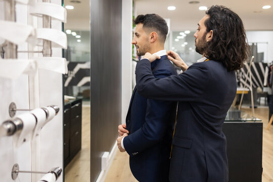 Tailor Adjusting Suit Jacket in a Suit Store