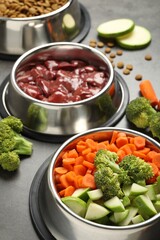 Dry pet food and natural products on grey table, closeup
