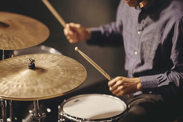 Obraz premium Cymbals clash powerfully during an energetic performance by a drummer in a dimly lit studio
