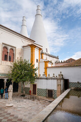 The Central Courtyard of the palace with the column at the center and chimneys in the background. Sintra, Lisbon District, Portugal