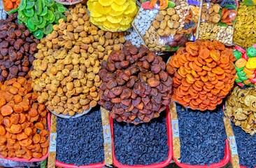 Market with a variety of dried fruits and nuts, including dates, dried apricots, raisins, candied fruits, and more.