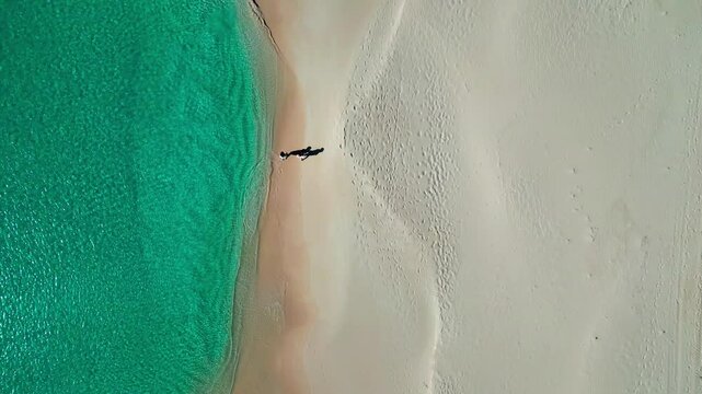 Beach in Barbuda with clear water. 2 Woman walking.