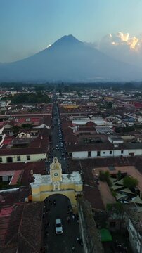 Vertical Drone view of the Iglesia de la Merced church and the Santa Catalina Arch in Antigua, Guatemala. View of the Agua volcano.