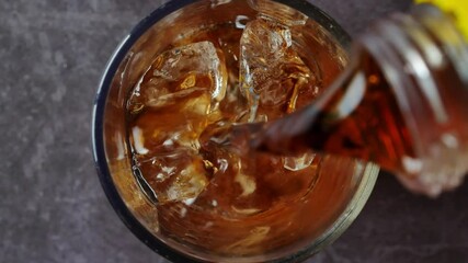 Cola soft drink with ice cubes, Close up of soda fizzy drink in Cold glass, macro of black soft drink background, Top view