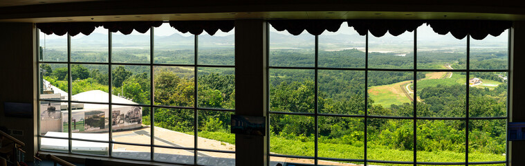 Panoramic View Of North Korea Lush Green Landscape And Distant Mountains Through Large Scenic Window