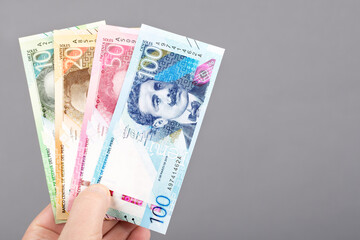 Peruvian money in the hand on a gray background.