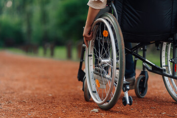Obraz premium Patient using wheelchair moving on path in rehab center park