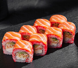 Fresh sushi rolls presented on a black stone plate
