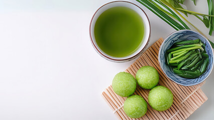Traditional Asian Green Tea and Sweet Rice Balls on a Bamboo Mat