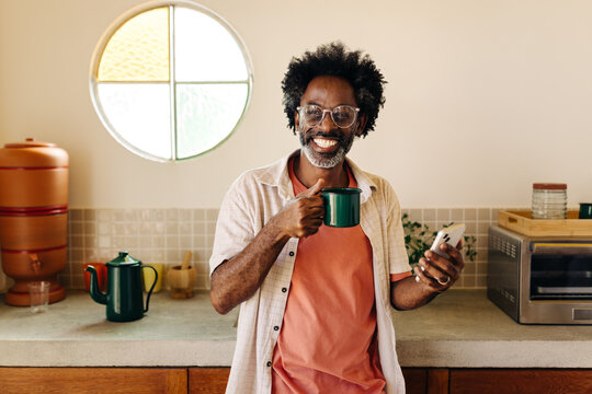 Happy man enjoying coffee in a Brazilian kitchen