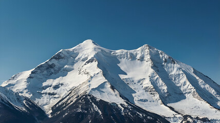 "Awe-Inspiring Snow-Covered Mountain Peaks Against a Clear Blue Sky"