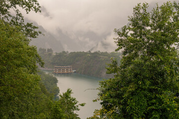 Floating Building on Tranquil Misty Lake Surrounded by Lush Greenery and Rugged Mountain Cliffs in Taiwan’s Wilderness
