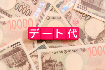 一万円札とブロックの上に書かれたデート代　経済