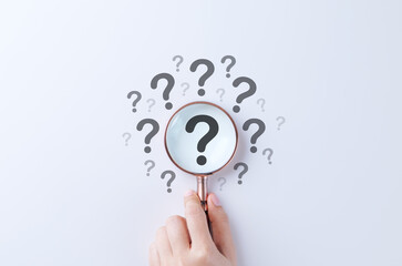 Question mark and root cause analysis concept. Hand holding magnifying glass over large question mark surrounded by smaller ones on white background, symbolizing analysis and problem-solving. solution