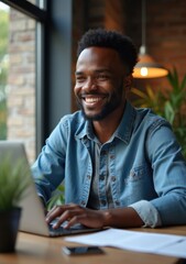 Man smiling while working on laptop in a cozy cafe during daytime
