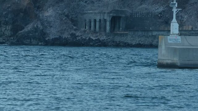海岸の崖に残された廃トンネルのある風景