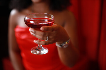 beautiful stylish glass goblet with red champagne in woman's hands