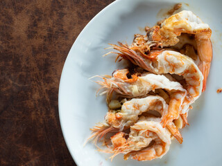 top view dish of roasted peeled prawns on white plate