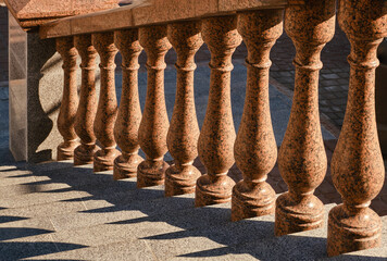 Fototapeta premium Granite balustrade and stairway. Granite ladder with handrail and granite stairs. Selective focus. 