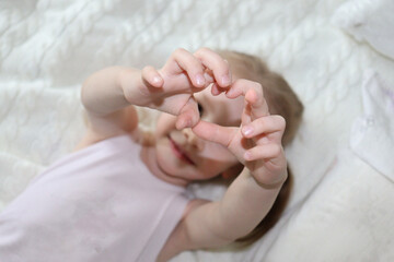 little girl is showing a heart with fingers. heart shaped fingers. 
