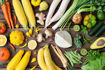 White, green, yellow, orange fruits and vegetables on wooden background.  Healthy food. Multicolored raw food.