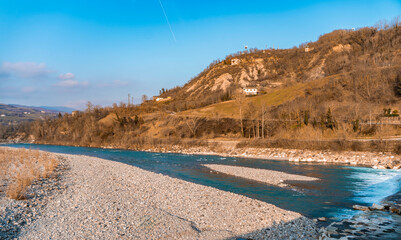 Italian landscape with rolling hills and a blue river flowing down the valley