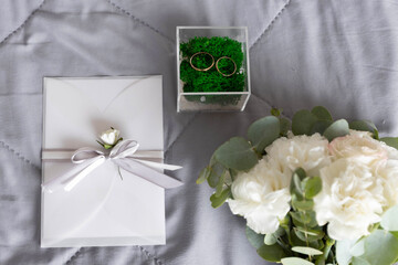 wedding details in the form of rings, invitations and bridal bouquet