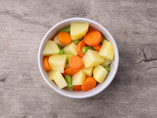 Cooked vegetables in a bowl over wooden table