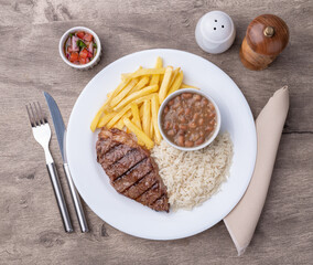 Grilled picanha beef, rice, beans and french fries. Typical brazilian executive dish