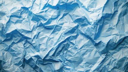 Obraz premium Crumpled blue paper texture showcasing intricate folds and shadows, ideal for backgrounds and artistic projects