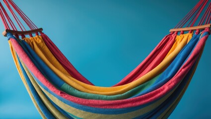 Vibrant Rainbow Colored Hammock Against Blue Background with Empty Space for Relaxation and Leisure Text or Branding
