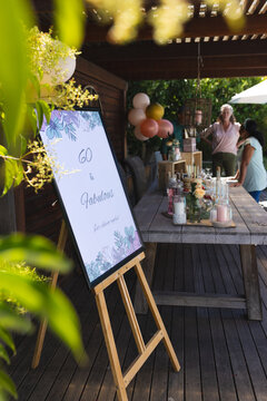 Celebrating 60th birthday with friends outdoors, enjoying decorations and refreshments