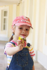 little girl showing a small bouquet of flowers to the camera. summer walk. flowers macro