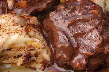 Creamy treats with chocolate and biscuit layers. Makro shot of two distinct Turkish milk-based desserts, one featuring layers of biscuit and a light cream.