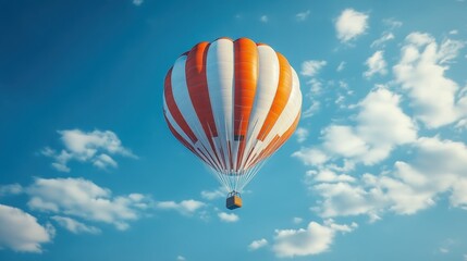 Naklejka premium Orange and white hot air balloon against blue sky with clouds in daylight