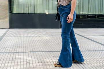 Fashionable woman wearing flared blue jeans outdoors
