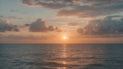 Calm ocean sunset with clouds reflecting on water surface creating warm tones in the sky and subtle ripples on the sea